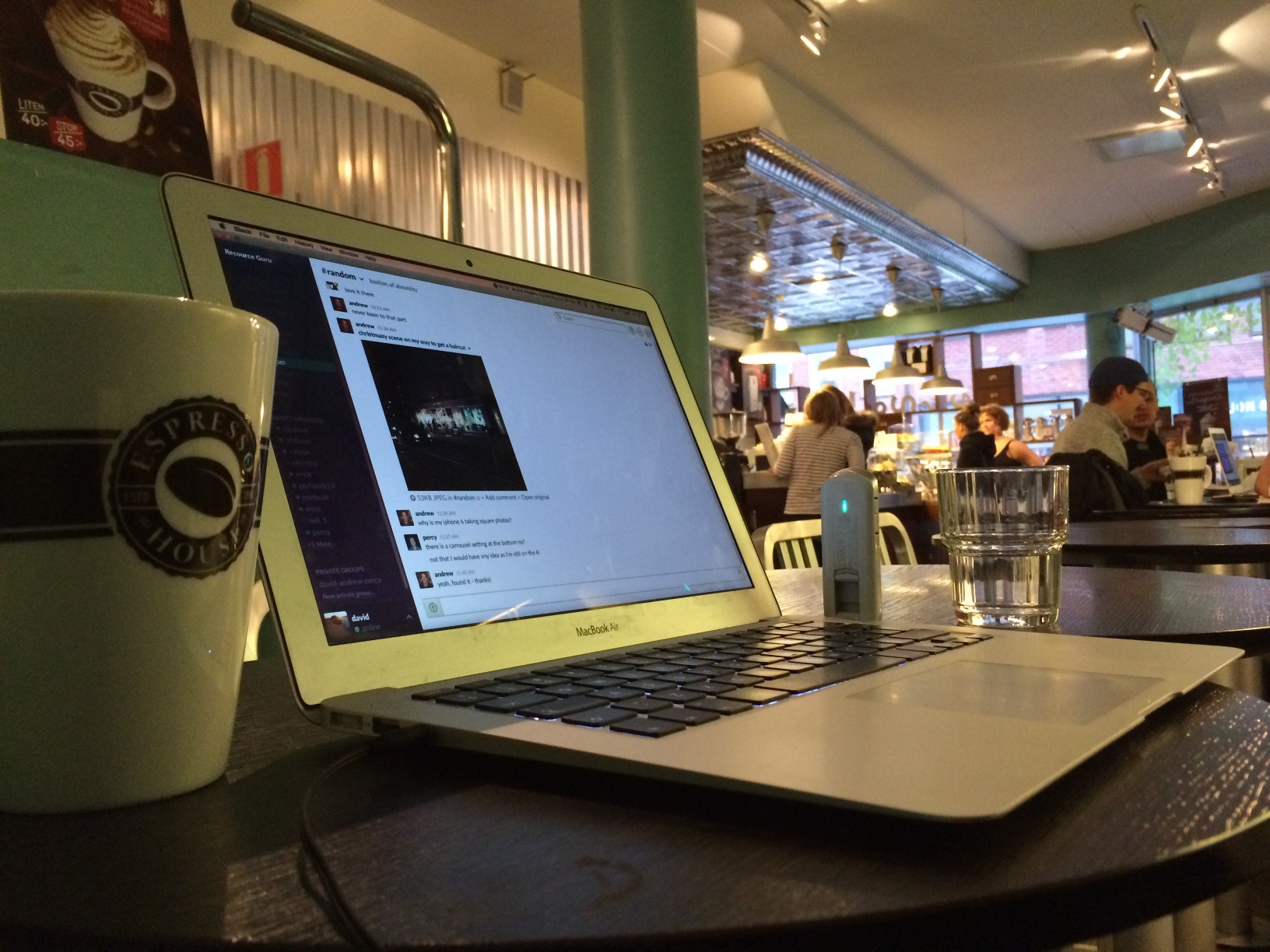 Laptop and coffee cup on table at bistro