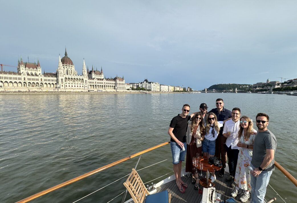 Eight members of Resource Guru's team on a boat sailing down the Danube River in Budapest.