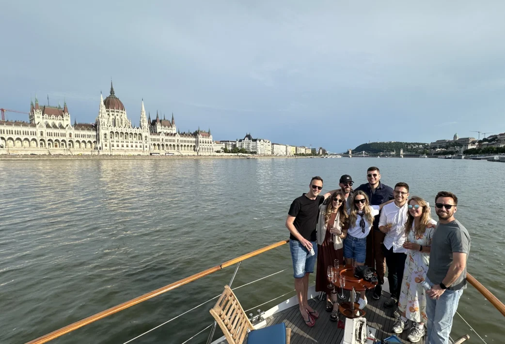 Eight members of Resource Guru's team on a boat sailing down the Danube River in Budapest.