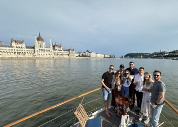 Eight members of Resource Guru's team on a boat sailing down the Danube River in Budapest.