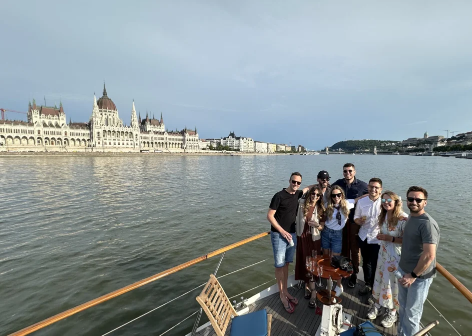 Eight members of Resource Guru's team on a boat sailing down the Danube River in Budapest.
