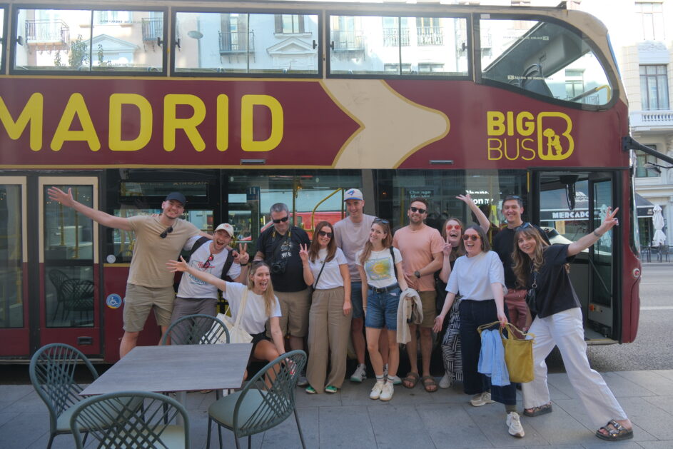 Some members of Team Guru beside a Madrid city tour bus.